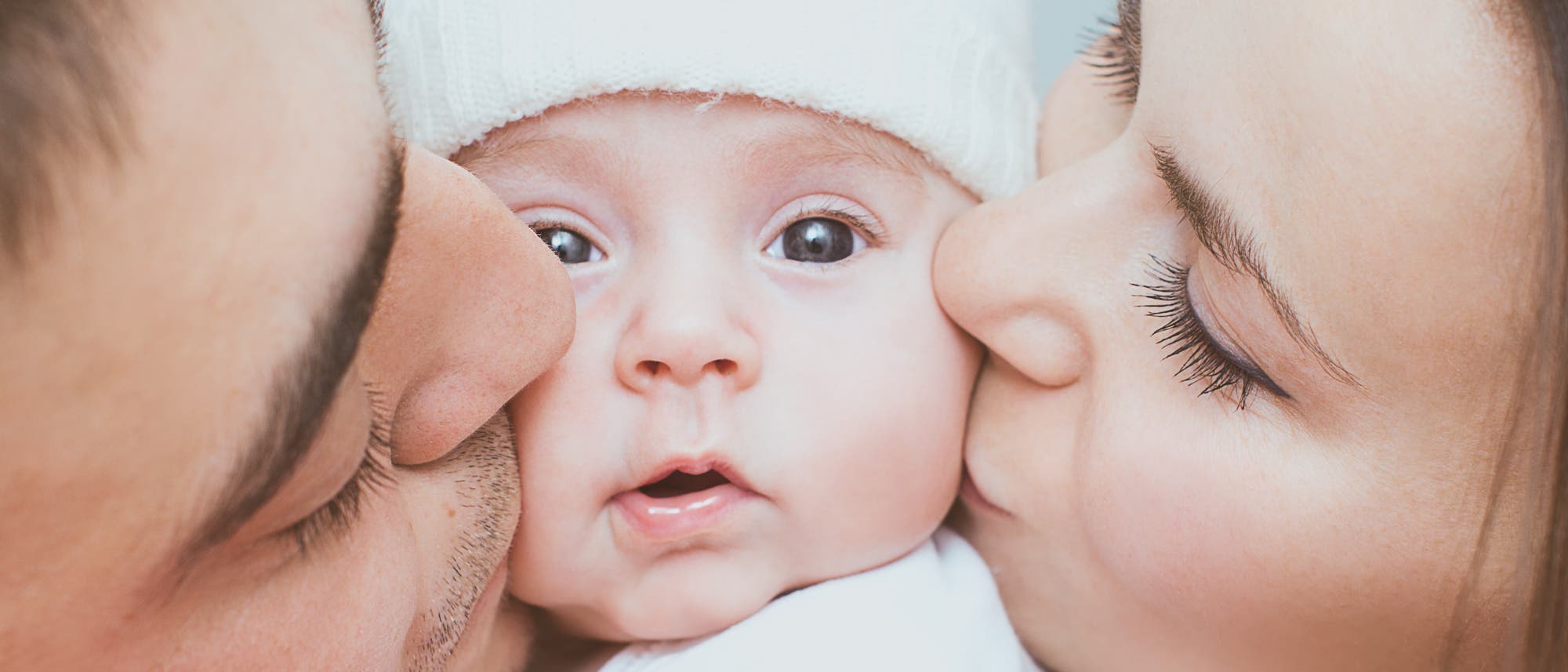 Eltern küssen ihr Baby