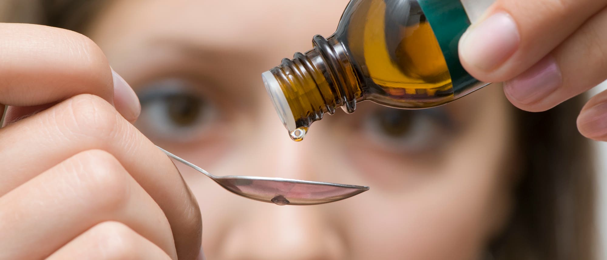 Medizin tropft auf einen Löffel Medizin tropft auf einen Löffel