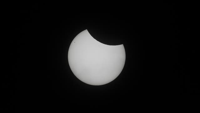 Weißlichtaufnahme der partiell verfinsterten Sonne mit Flecken.