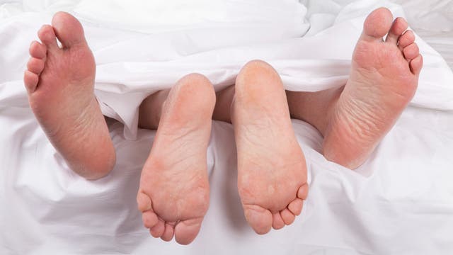 Seniorenfüße unter dem Bettlaken